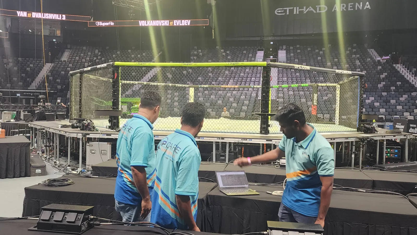 IP Care engineers checking network connectivity beside the Octagon at Etihad Arena before UFC 333