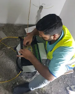 IP Care engineer splicing single-mode fiber into a splice tray on site at Al Jeel Tower