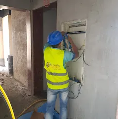 IP Care technician installing and wiring an access control panel enclosure at Al Jeel Tower